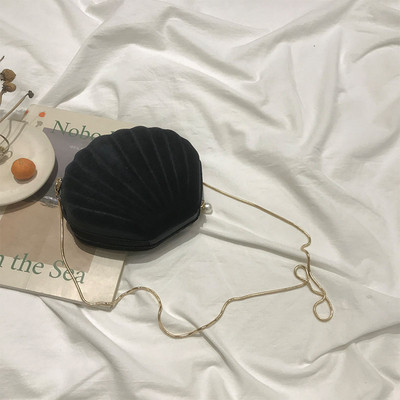 O geantă mică de damă din catifea în formă de scoică cu mâner lung