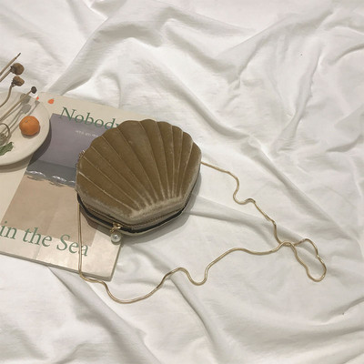 O geantă mică de damă din catifea în formă de scoică cu mâner lung