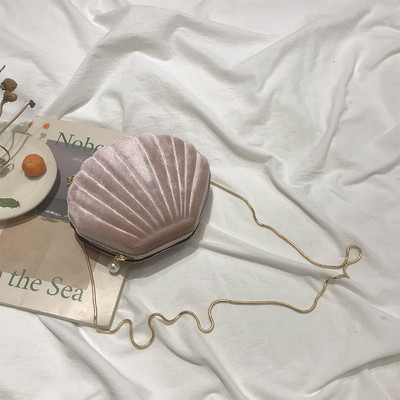 O geantă mică de damă din catifea în formă de scoică cu mâner lung