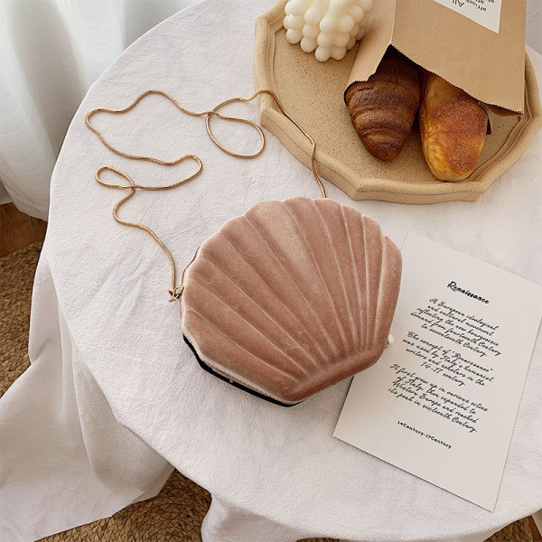 O geantă mică de damă din catifea în formă de scoică cu mâner lung