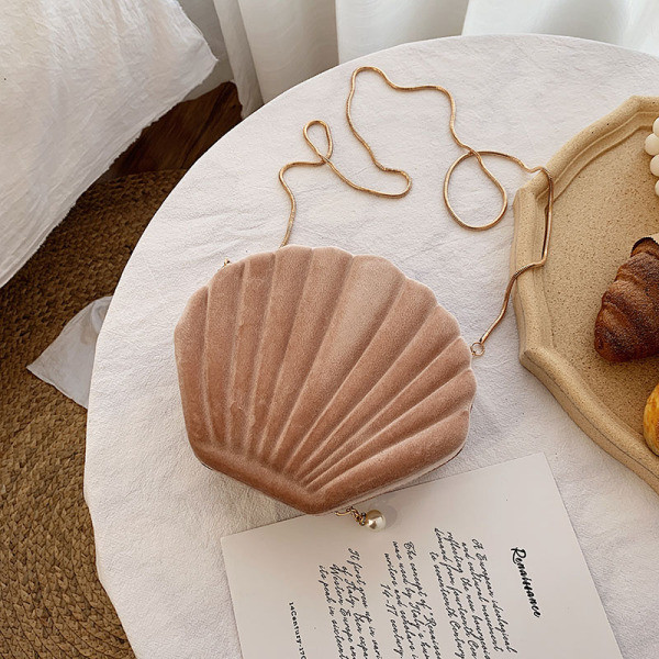 O geantă mică de damă din catifea în formă de scoică cu mâner lung