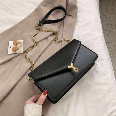 Moderni moteriška rankinė su metaliniu užsegimu ir ilga rankena