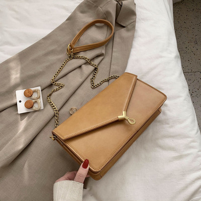 Moderni moteriška rankinė su metaliniu užsegimu ir ilga rankena