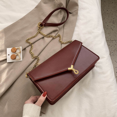 Moderni moteriška rankinė su metaliniu užsegimu ir ilga rankena