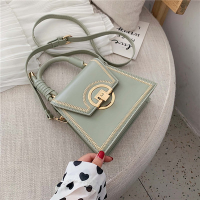 Moderna sieviešu soma ar metāla aizdari un garu un īsu ādas rokturi