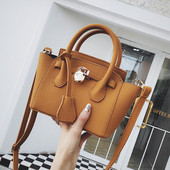 Mažas moteriškas krepšys su metaliniu elementu ir dviem rankenomis