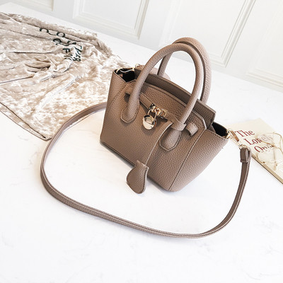 Mažas moteriškas krepšys su metaliniu elementu ir dviem rankenomis