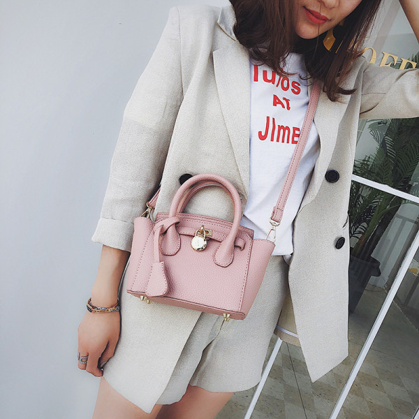 Mažas moteriškas krepšys su metaliniu elementu ir dviem rankenomis