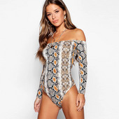 Sieviešu ķermenis ar čūskas apdruku, atkailinātiem pleciem un garām piedurknēm