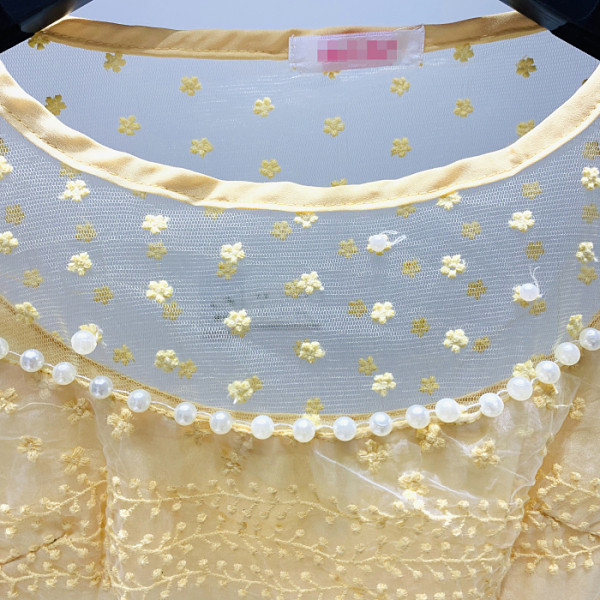 Moderna sieviešu kleita ar īsām piedurknēm, ovālu kakla izgriezumu un izšuvumu