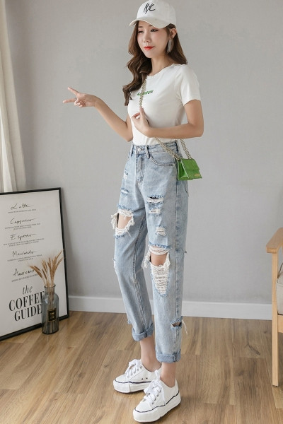 Ikdienišķi zili sieviešu džinsi ar augstu vidukli un saplēstiem motīviem