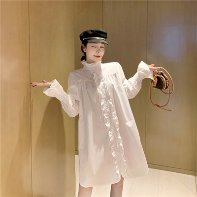 Széles női ruha fürtökkel és magas gallérral