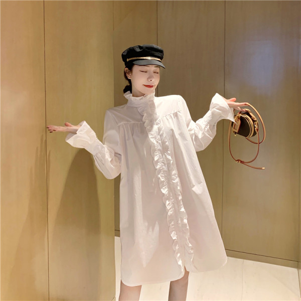 Széles női ruha fürtökkel és magas gallérral