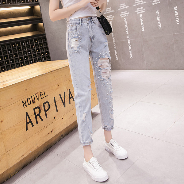 Modern női farmer gyöngyökkel, szakadt motívumokkal