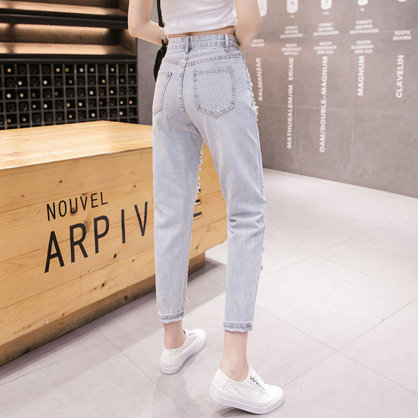 Modern női farmer gyöngyökkel, szakadt motívumokkal