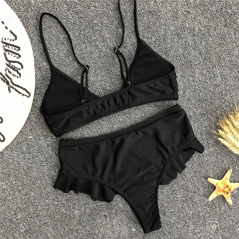 Mūsdienīgs melns divdaļīgs peldkostīms ar trīsstūrveida augšdaļu un augstu vidukli