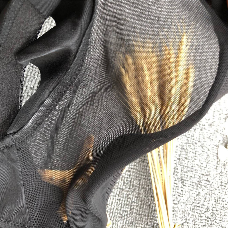 Mūsdienīgs melns divdaļīgs peldkostīms ar trīsstūrveida augšdaļu un augstu vidukli