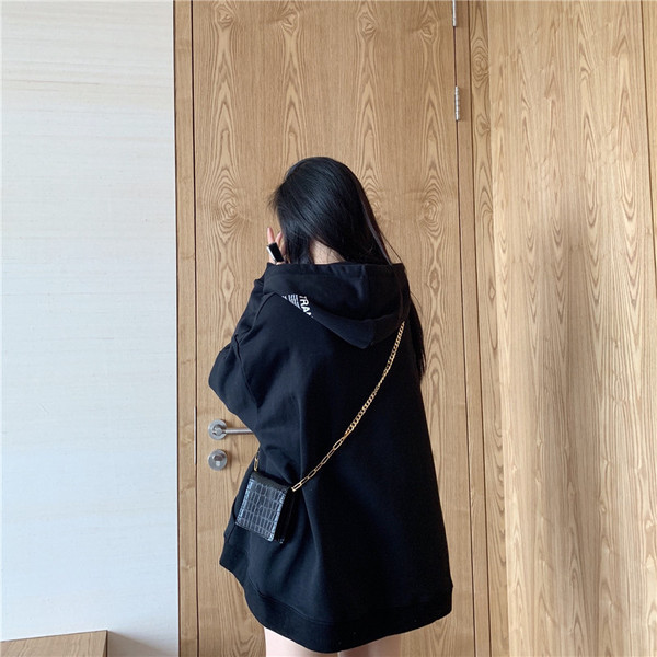 Széles női pulóver kapucnival és zsebbel