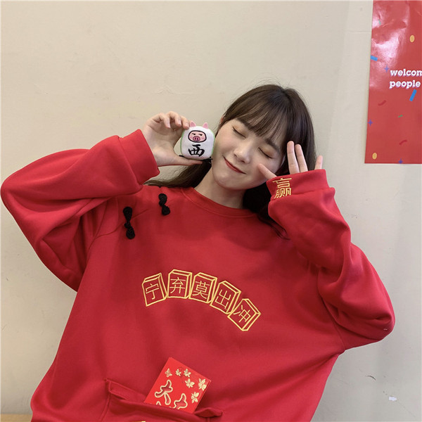 Széles női pulóver zsebbel és hímzéssel