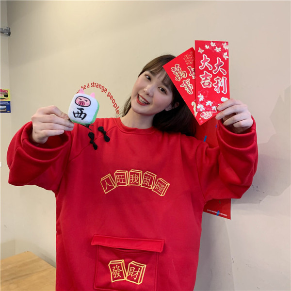 Széles női pulóver zsebbel és hímzéssel