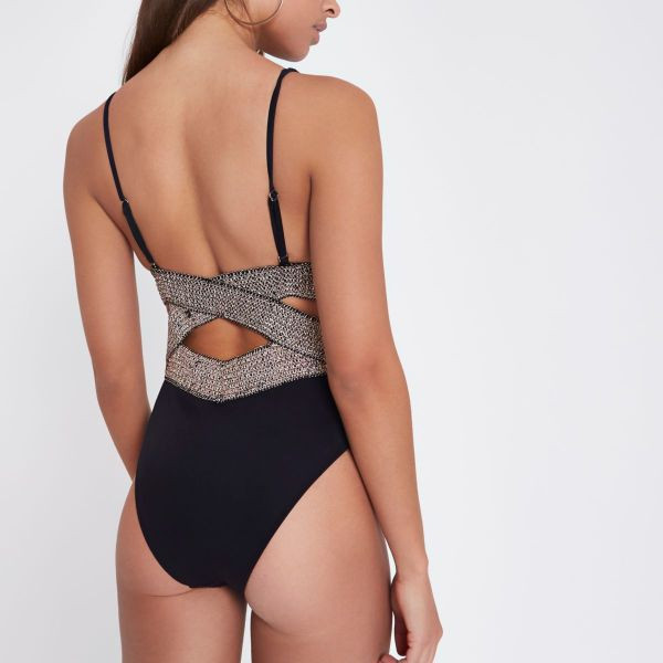 Stilīgs melns pilns peldkostīms ar dziļu kakla izgriezumu un izgriezumiem