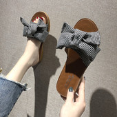 Įprastos moteriškos šlepetės plokščiu padu ir kaspinu