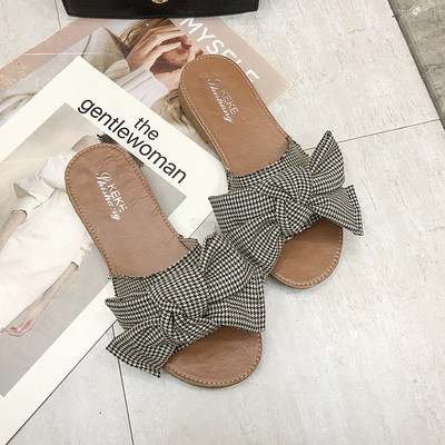 Įprastos moteriškos šlepetės plokščiu padu ir kaspinu