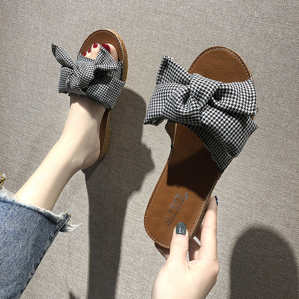 Įprastos moteriškos šlepetės plokščiu padu ir kaspinu