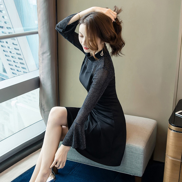 Stilinga moteriška juoda suknelė ilgomis rankovėmis ir žema apykakle