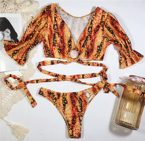 Moderns divdaļīgs peldkostīms ar īsām piedurknēm, saitēm un dažādiem rakstiem