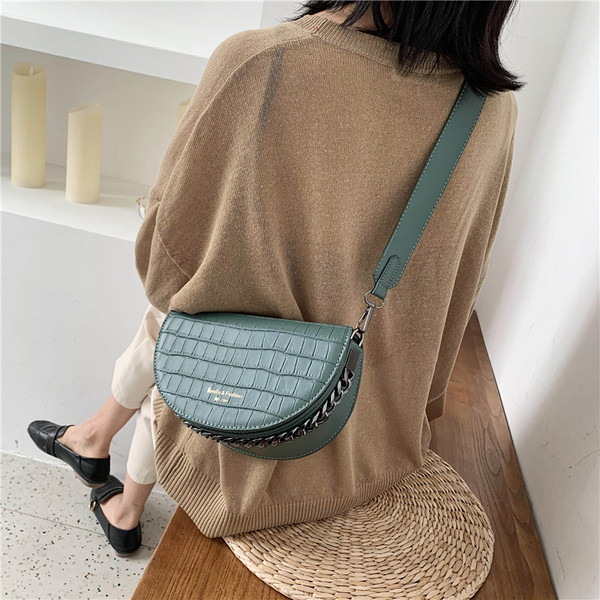 Sieviešu ādas soma ar platu siksnu un reljefu pārvalku