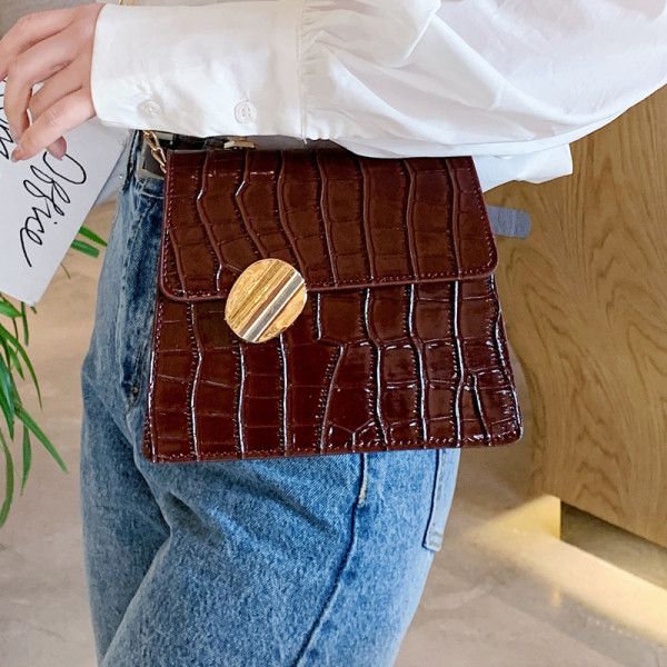 Modern női táska dombornyomott huzattal és fém fogantyúkkal