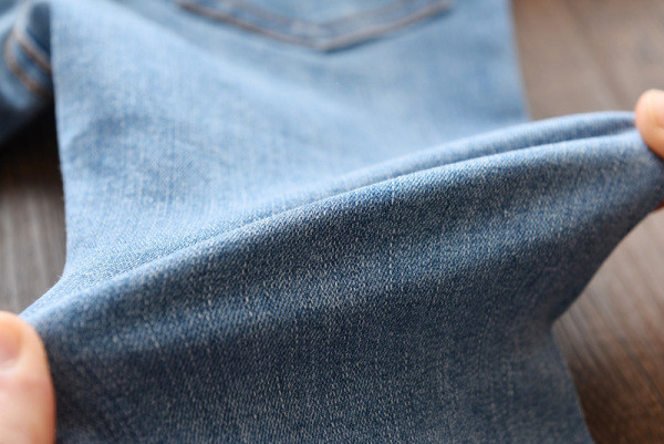 Mūsdienīgi bērnu džinsi meitenēm ar lentīti un saplēstiem motīviem