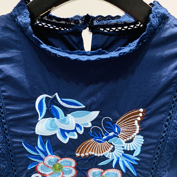 Moodne naiste särk madala kraega ja sinise tikandiga