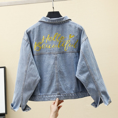 Moteriškos džinsinės striukės platus modelis su klasikine apykakle ir užrašu