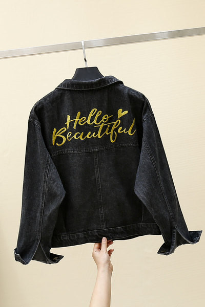 Moteriškos džinsinės striukės platus modelis su klasikine apykakle ir užrašu