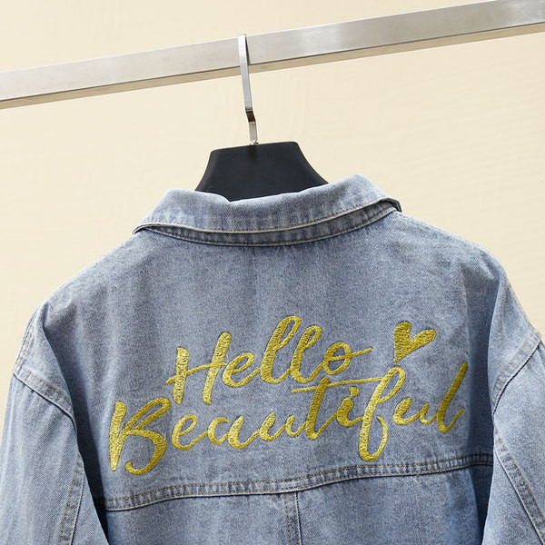 Moteriškos džinsinės striukės platus modelis su klasikine apykakle ir užrašu