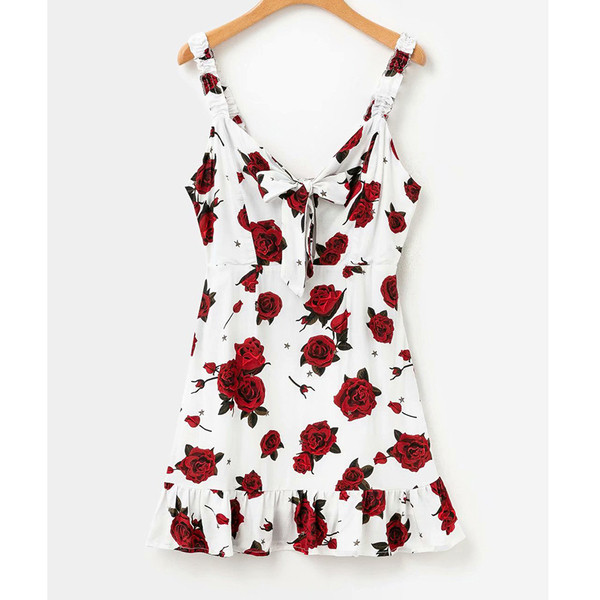 Įprasta moteriška trumpa suknelė su plonais petnešėlėmis, gėlių raštu ir gilia iškirpte