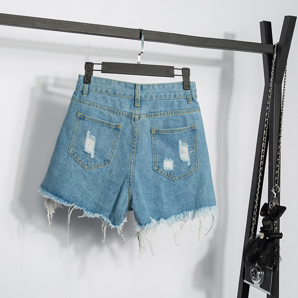 Didelio dydžio moteriški šortai aukštu liemeniu, plėšytais motyvais ir blizgučiais