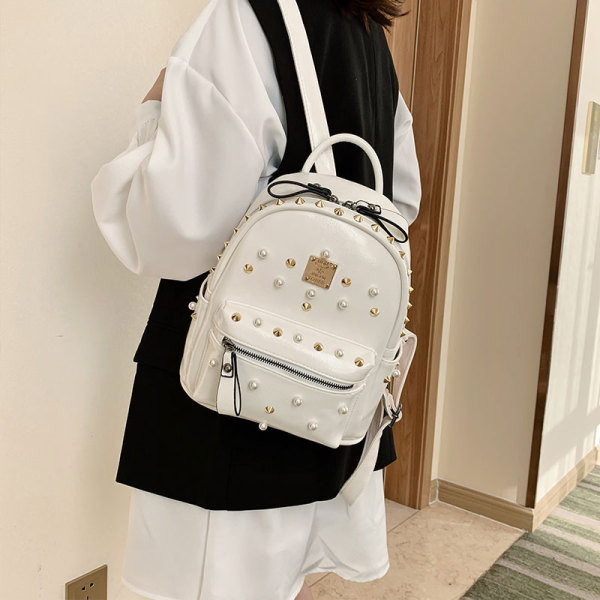 Moderni moteriška odinė kuprinė su metaliniais elementais ir perlais