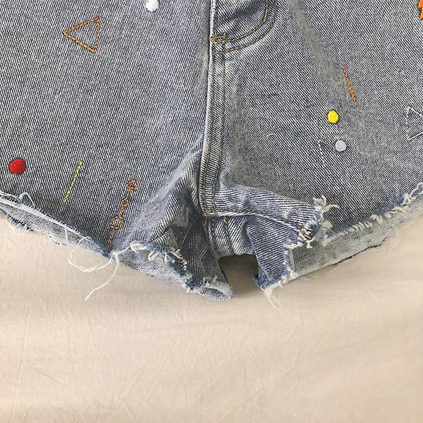 Džinsiniai šortai aukštu juosmeniu, sagos ir siuvinėjimai