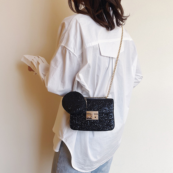 Stilinga rankinė su blizgiomis dalelėmis ir metaliniu užsegimu