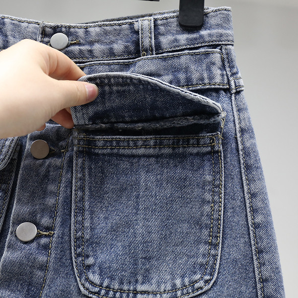 Laisvas moteriškas sijonas aukštu juosmeniu, kišenėmis ir sagomis