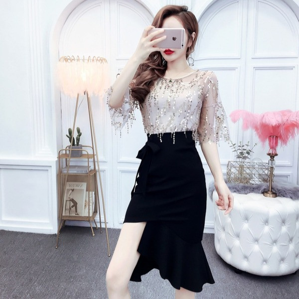 Modernus moteriškas asimetrinio sijono aukštu juosmeniu ir palaidinės su blizgučiais komplektas