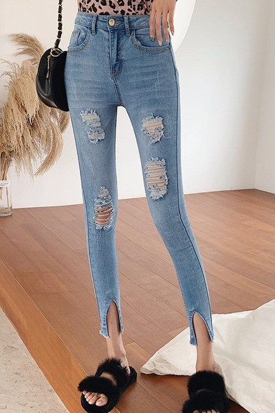 Naujo modelio spyruokliniai džinsai prigludę su suplyšusiais motyvais