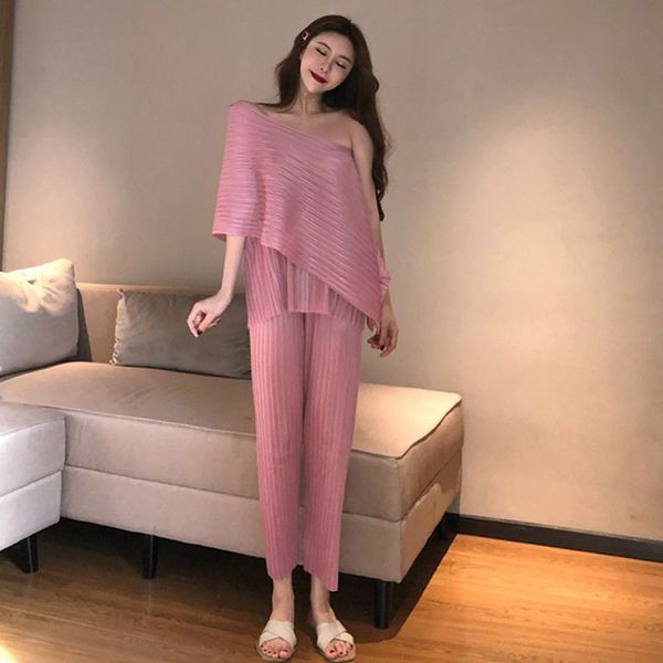 Modernus moteriškas asimetriškos palaidinės ir ilgų kelnių komplektas