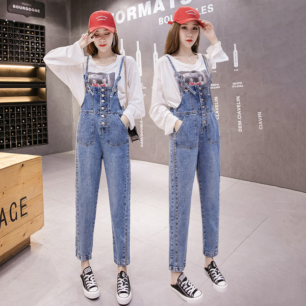 Įprastas džinsinis moteriškas kombinezonas su plonais petnešėlėmis ir mėlynos spalvos sagomis