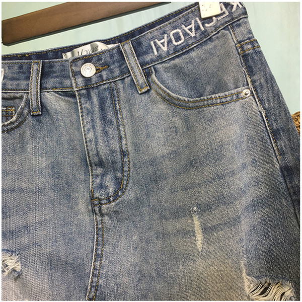 Női farmerszoknya, magas derékkal, szakadt motívumokkal