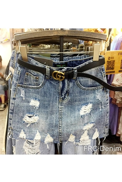 Modern női farmerszoknya szakadt motívumokkal, magas derékkal