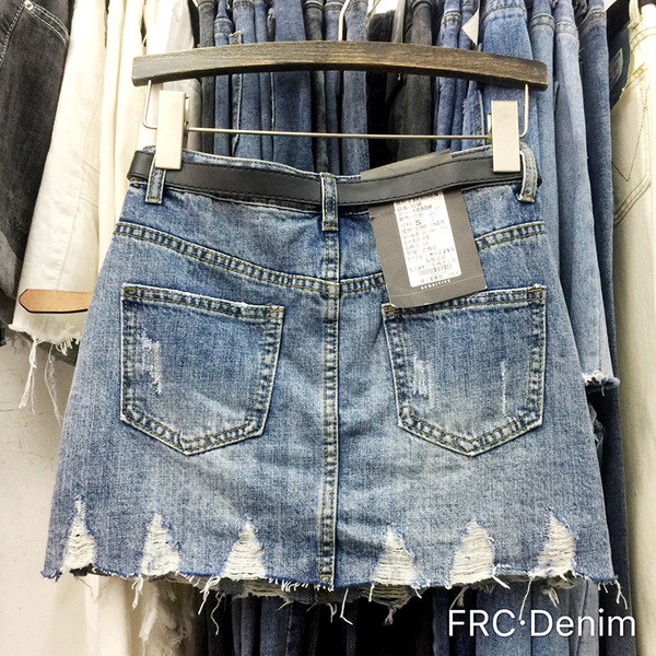 Modern női farmerszoknya szakadt motívumokkal, magas derékkal